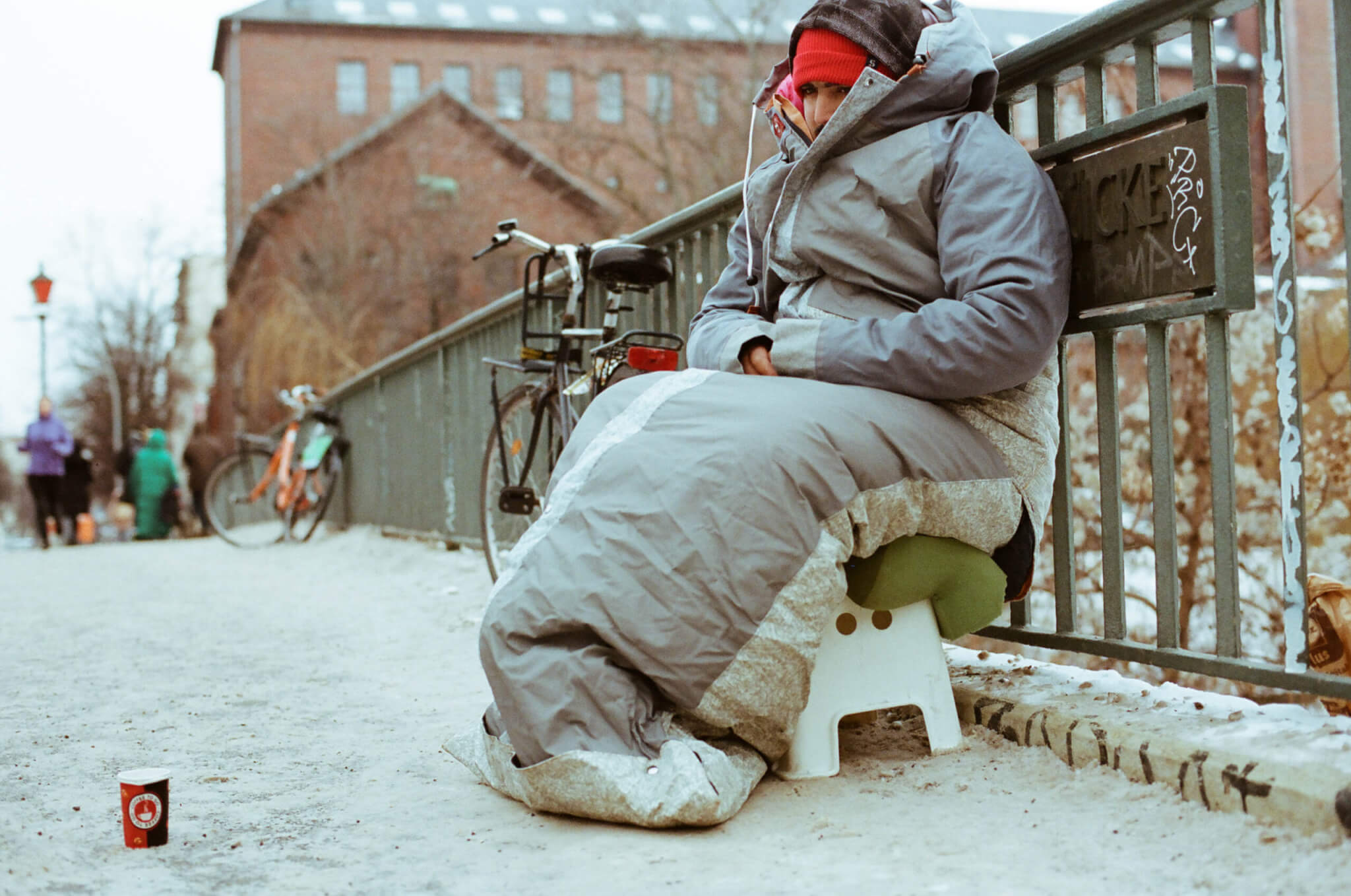 {:de}Sheltersuit Schlafsack – Ein warmer Mantel in dem Obdachlose schlafen können.{:}{:en}Sheltersuit sleeping bag – A warm coat in which homeless people can sleep.{:}